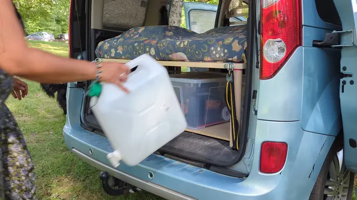 Jerrican d'eau et caisses rangés sous le lit